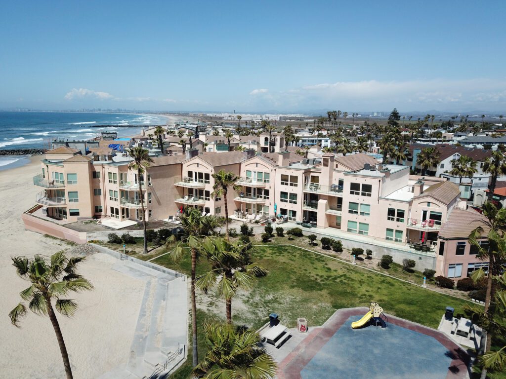 A coastal residential area with multi-story buildings and palm trees.